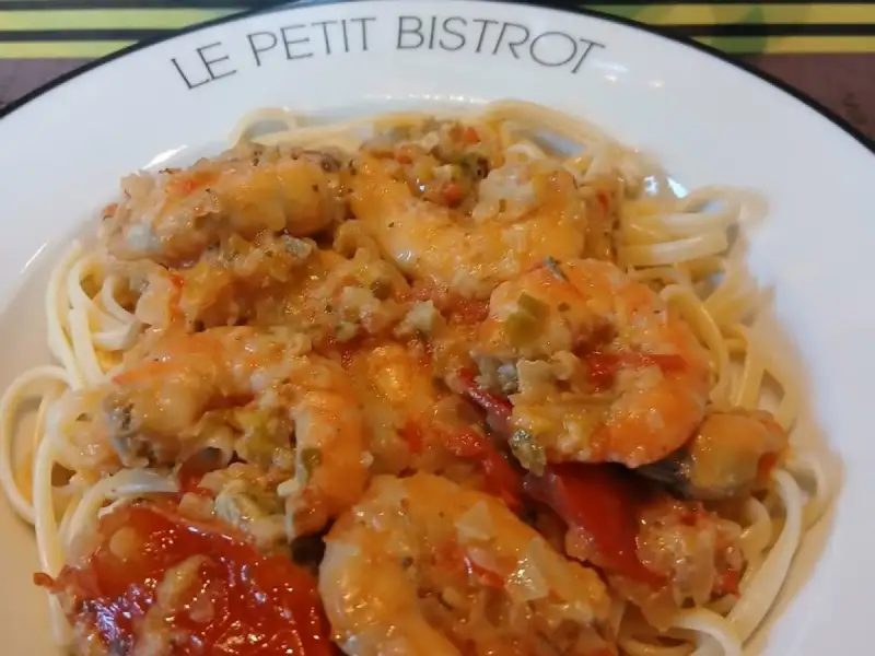Teller mit Spaghetti mit Scampi in Tomatensoße mit Knoblauch und Petersilie