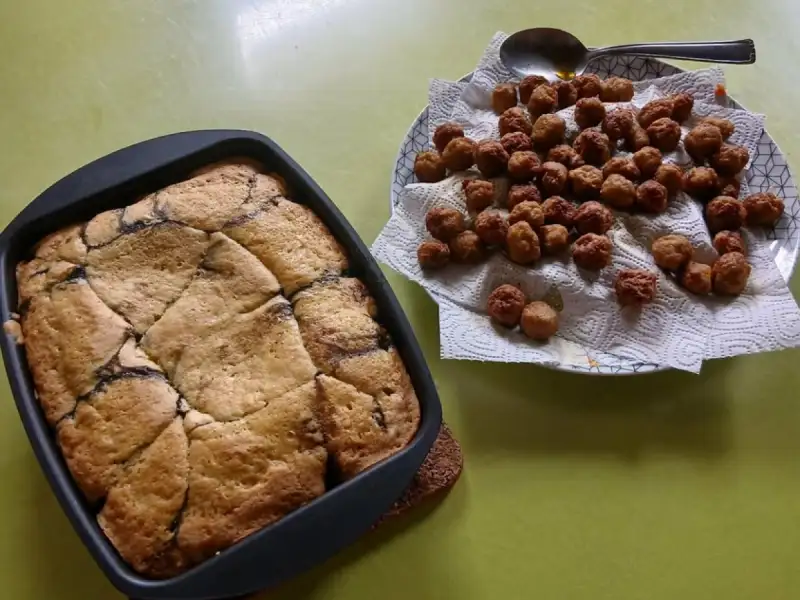 Kleine Fleischbällchen für die Suppe auf Küchenpapier, neben einem Kuchen